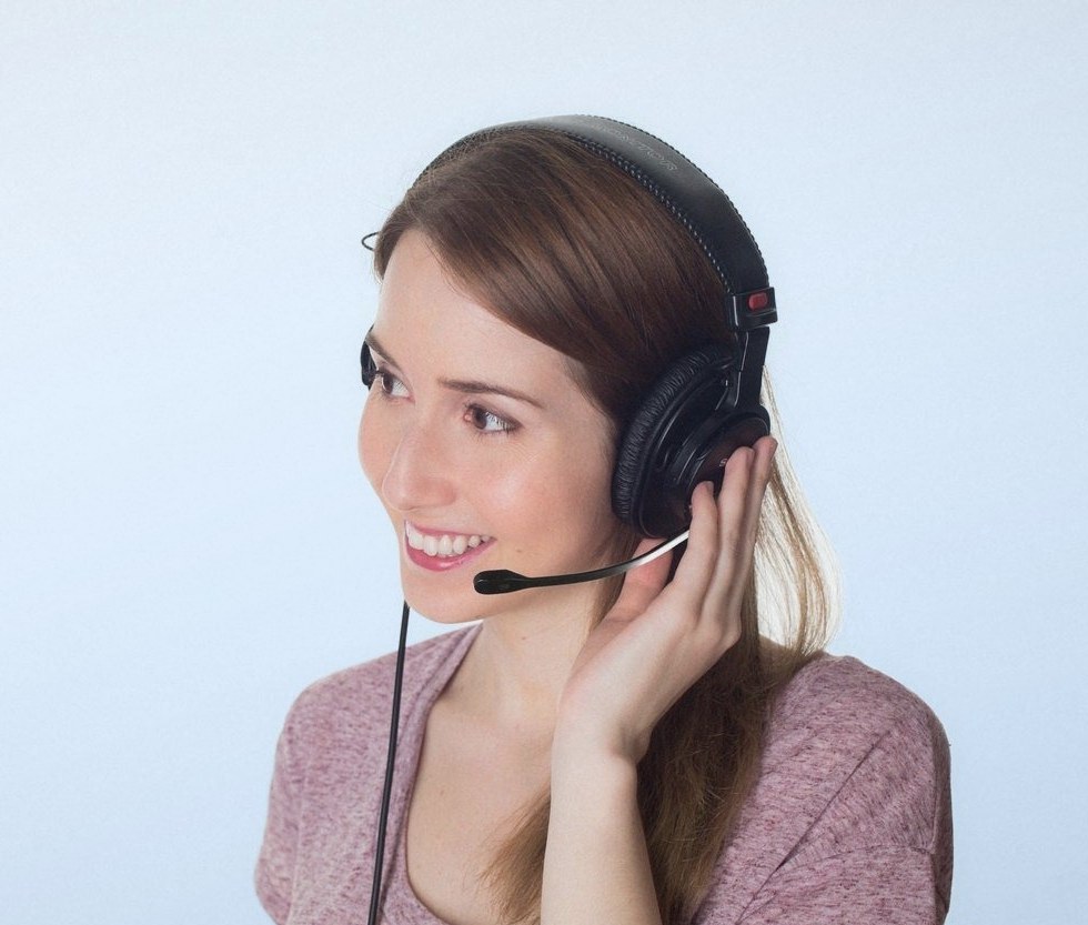 Smiling woman in a purple top wearing a headset